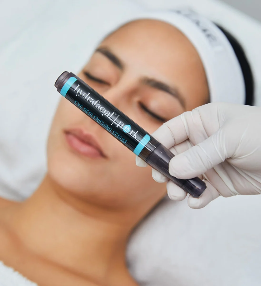 Козметолог нанася серум Hydrafacial Perk на лицето на клиентка